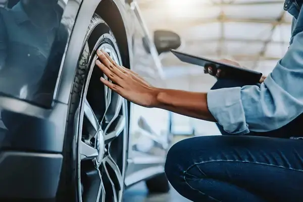 Homme inspectant lune voiture d'occasion pour estimer la valeur du véhicule.